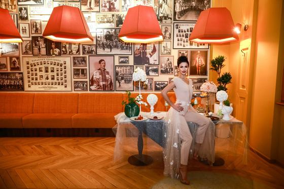 A wedding dress in the Royal Guard café, with historic photographs on the wall