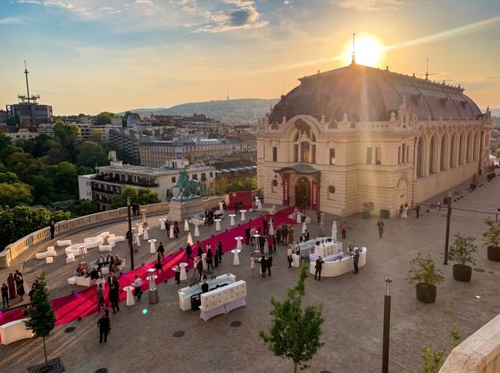 Reception in Csikós Court at sunset with a red carpet and cocktail tables
