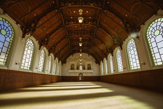 The empty Royal Riding Hall with open roof timbers and arched windows
