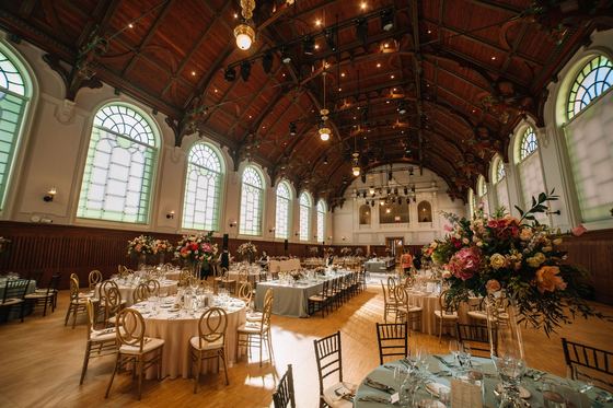 Wedding setting in the riding hall with floral decoration and gold chairs